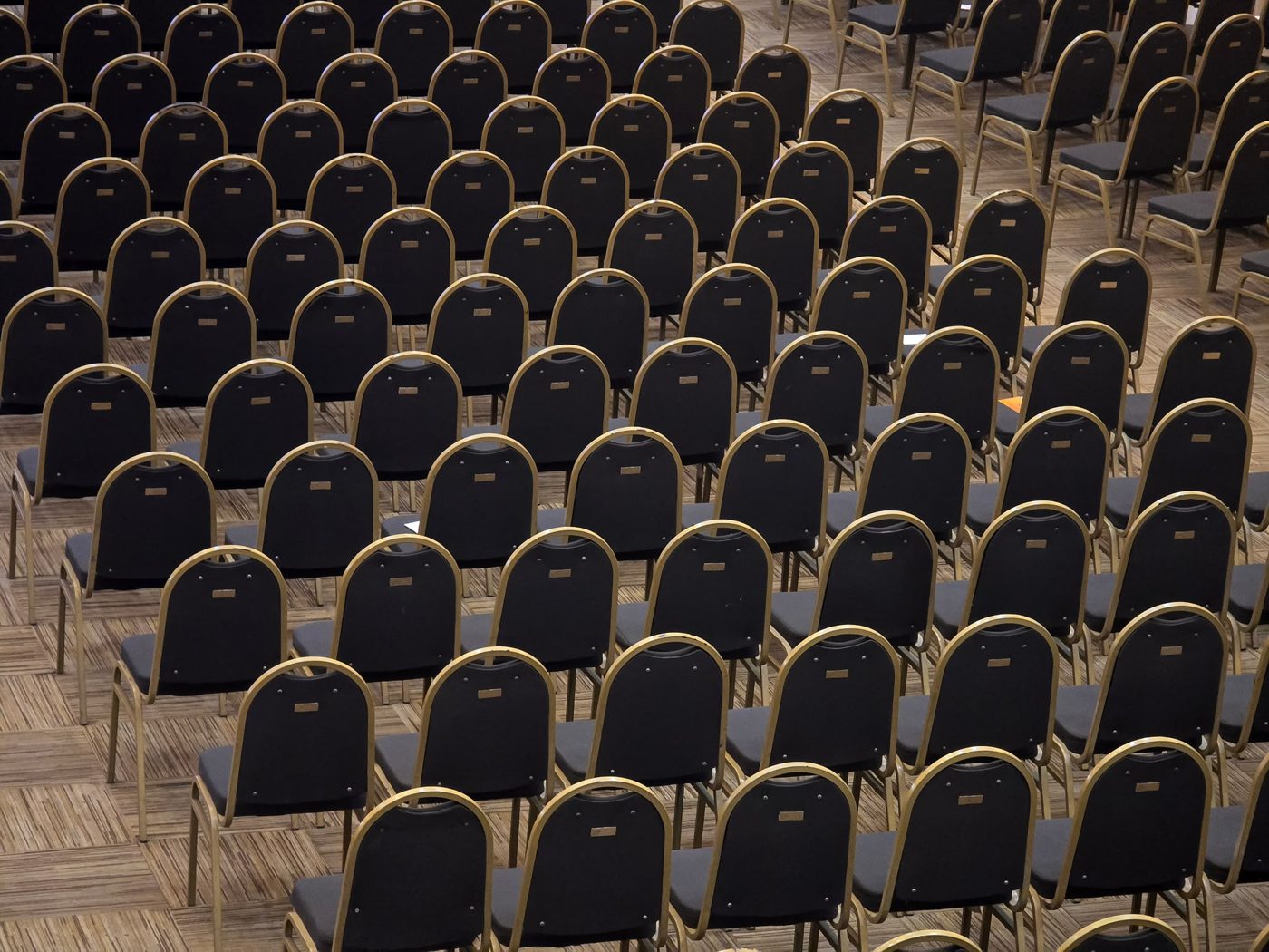 Gepolsterte Stuhlreihen in einem Konferenzraum – Polsterreinigung für Büros